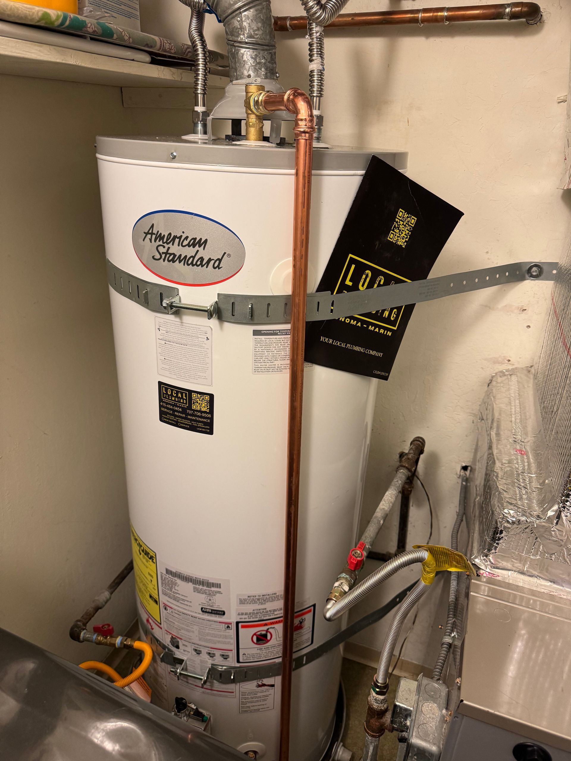 White American Standard water heater with copper pipe in utility room.