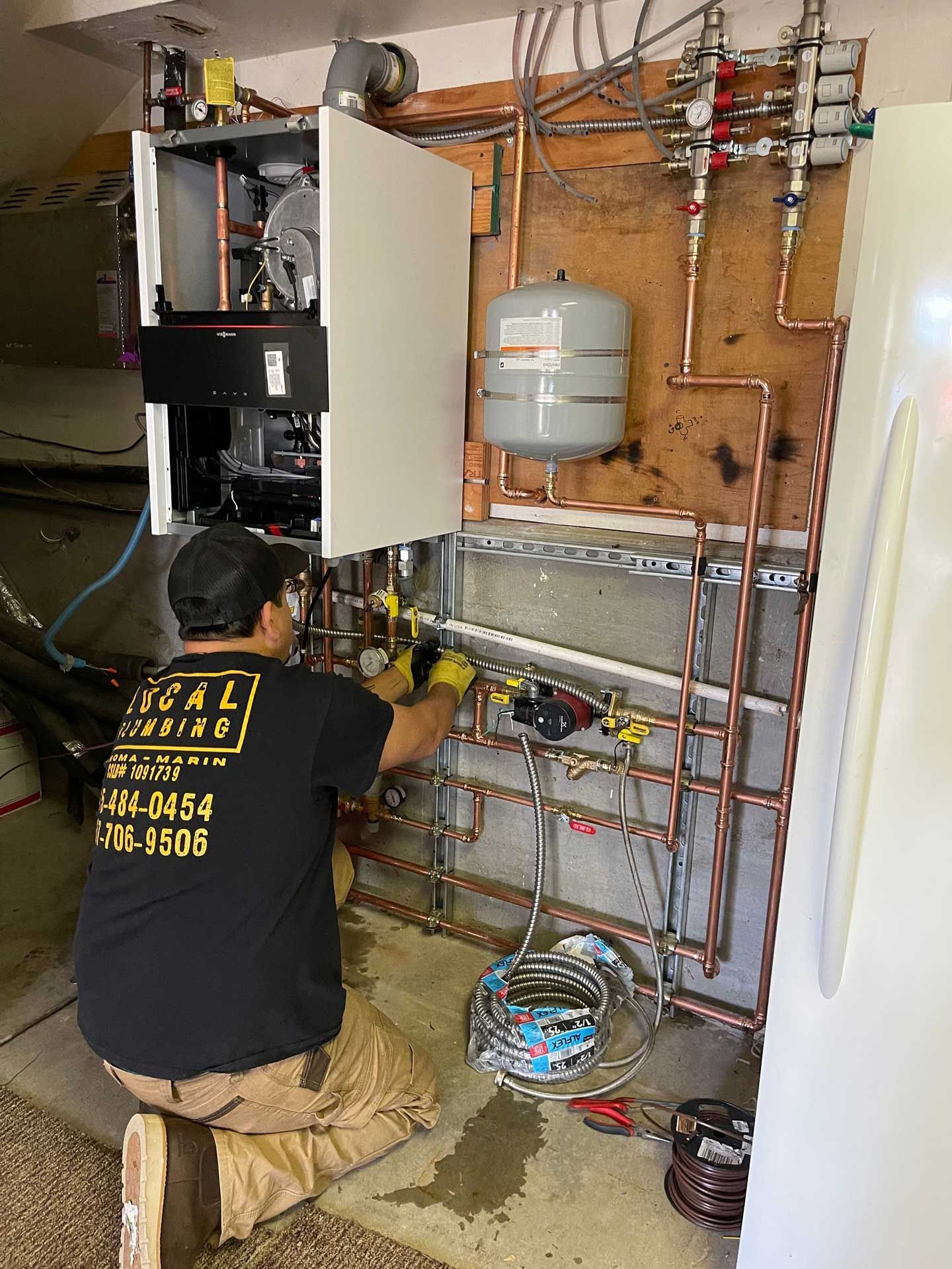 Local Plumbing technician working on a wall-hung boiler and copper piping