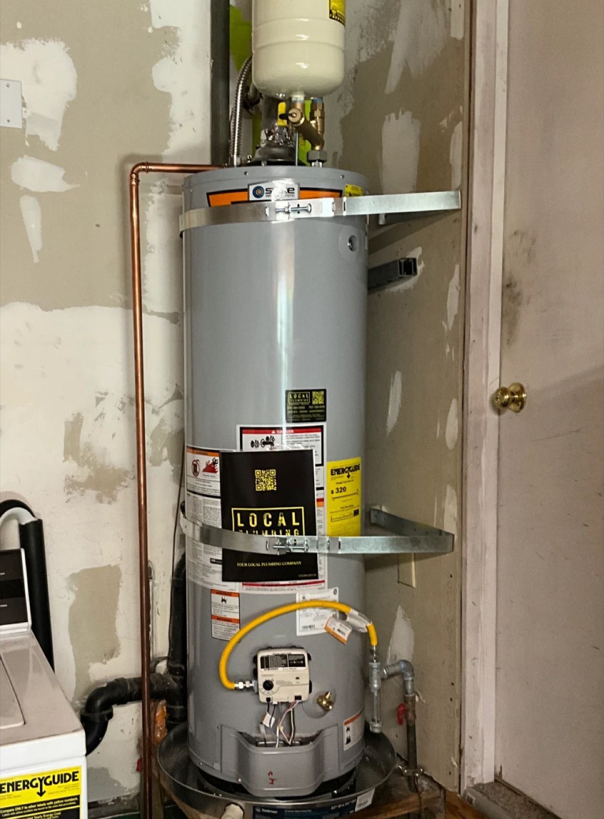 State gas water heater installed by Local Plumbing in a garage, with expansion tank, seismic straps and copper piping