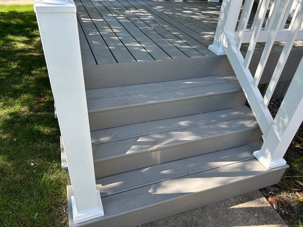 Gray composite deck with white railings and steps.