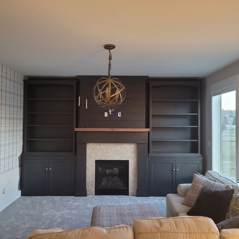 Living room with dark gray built-in shelves, fireplace, and a light-colored sofa.