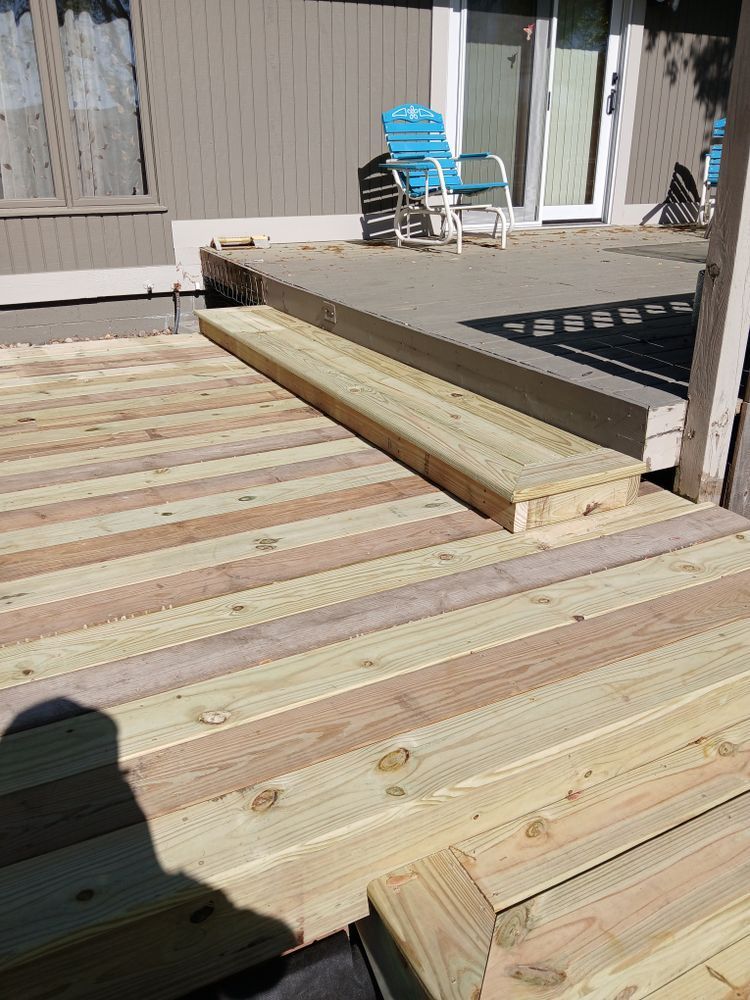 Wooden deck with steps leading to a higher level, blue chair in the background.