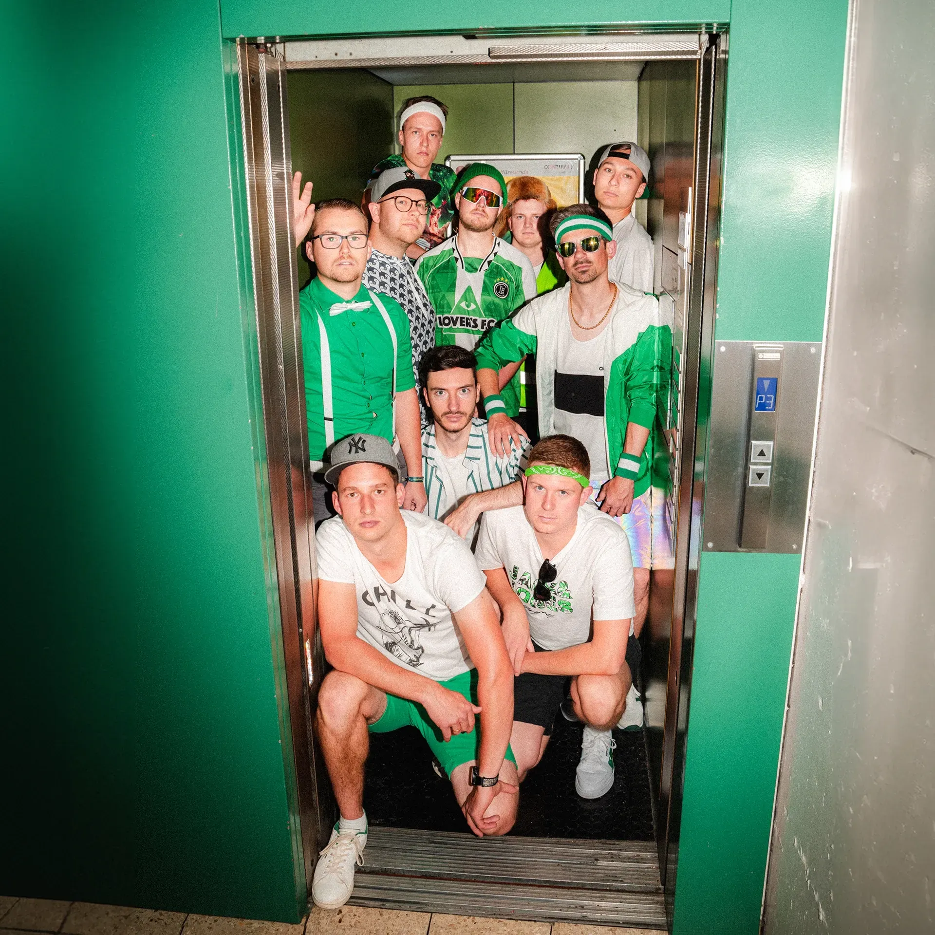 Eine Gruppe von Menschen posiert für ein Foto in einem Aufzug