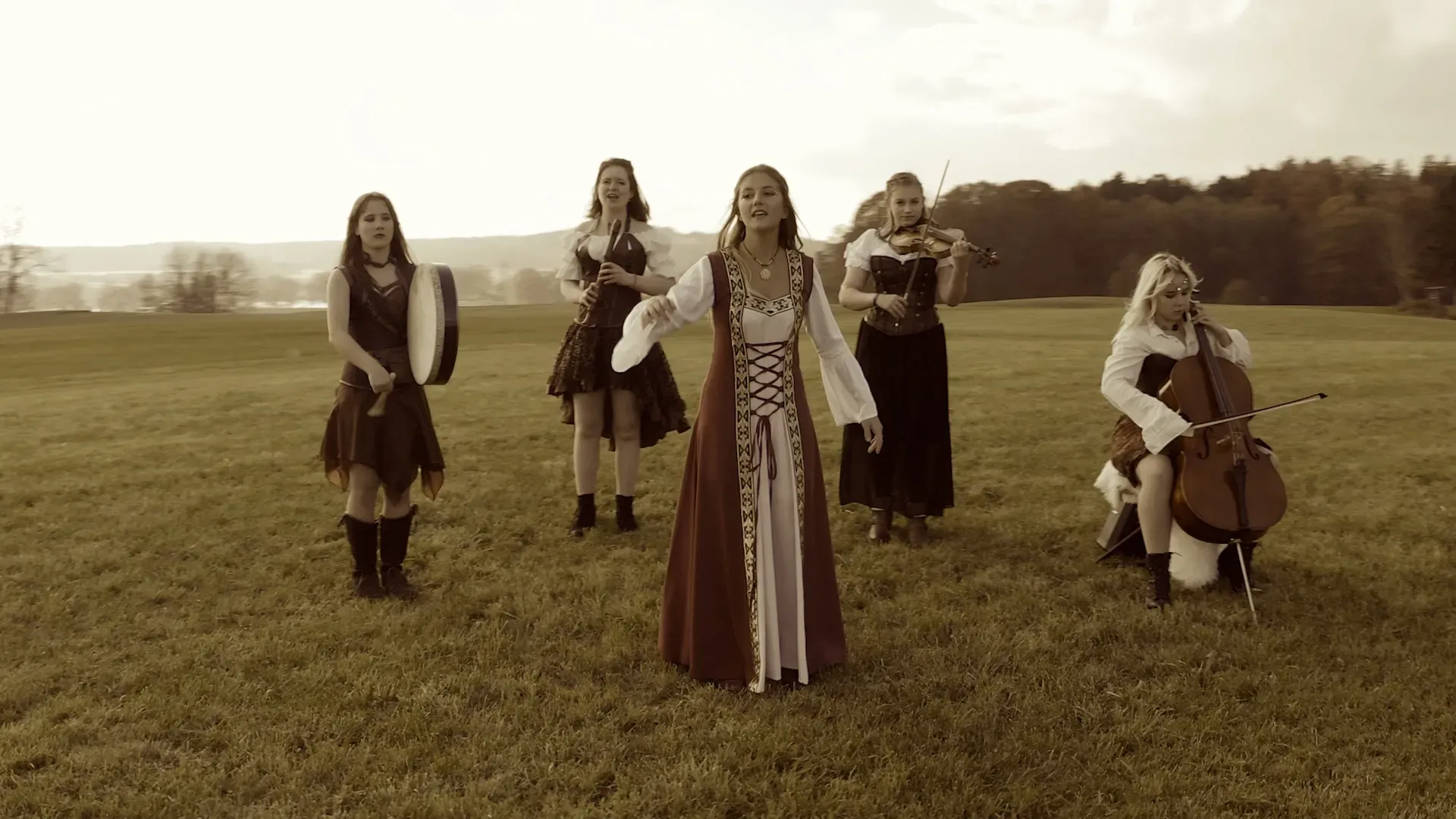 Eine Gruppe Frauen steht auf einem Feld und spielt Instrumente.
