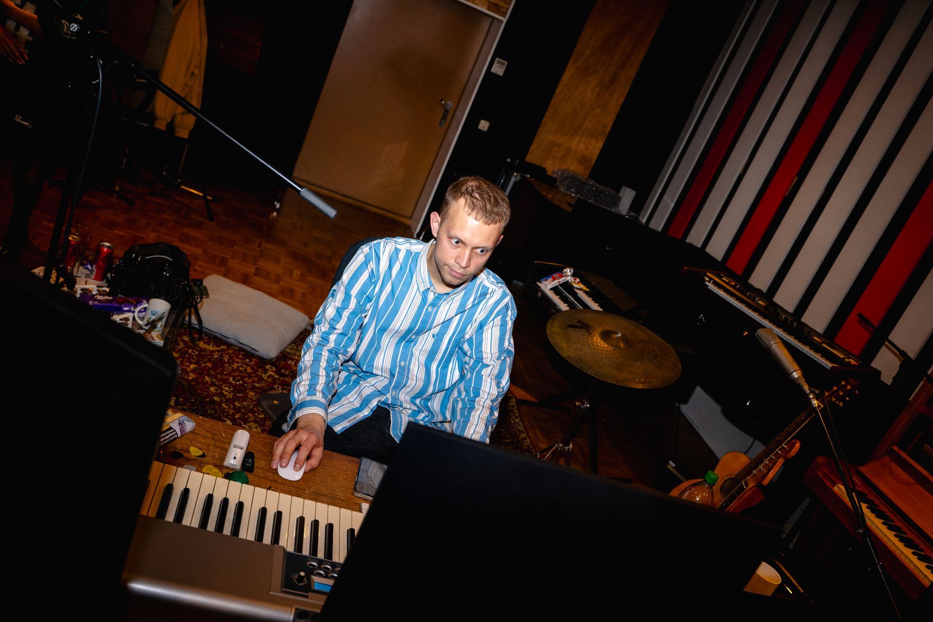 Ein Songcamp Teilnehmer sitzt im Studio umgeben von Musikinstrumenten.