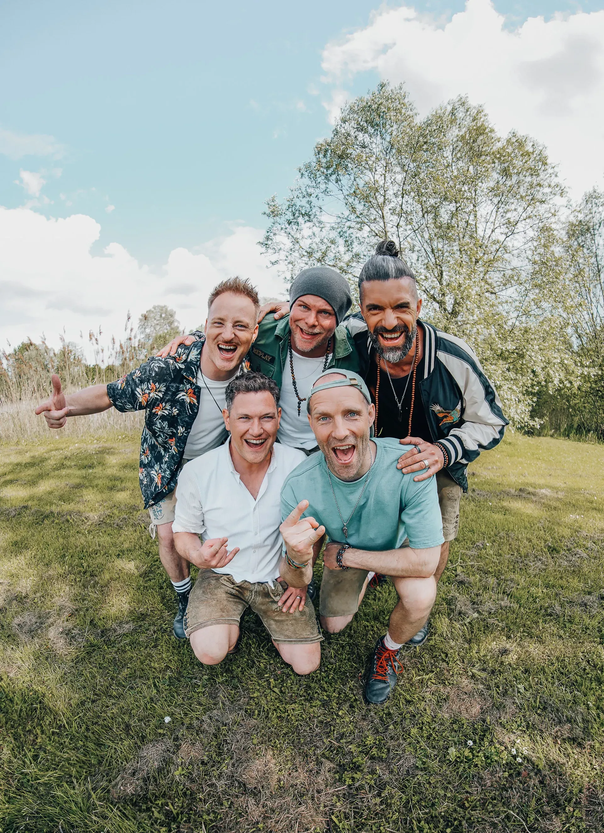 Eine Gruppe Männer posiert auf einer Wiese für ein Foto.