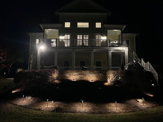 A large white house is lit up at night.