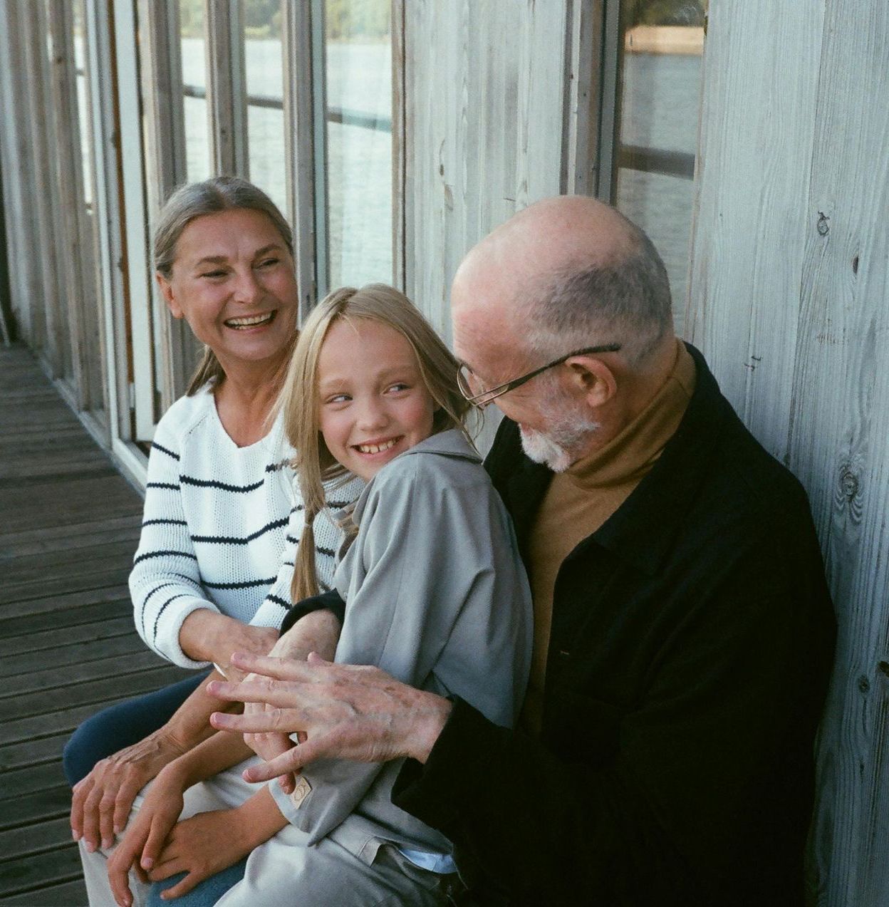 A man and a woman are sitting next to a little girl