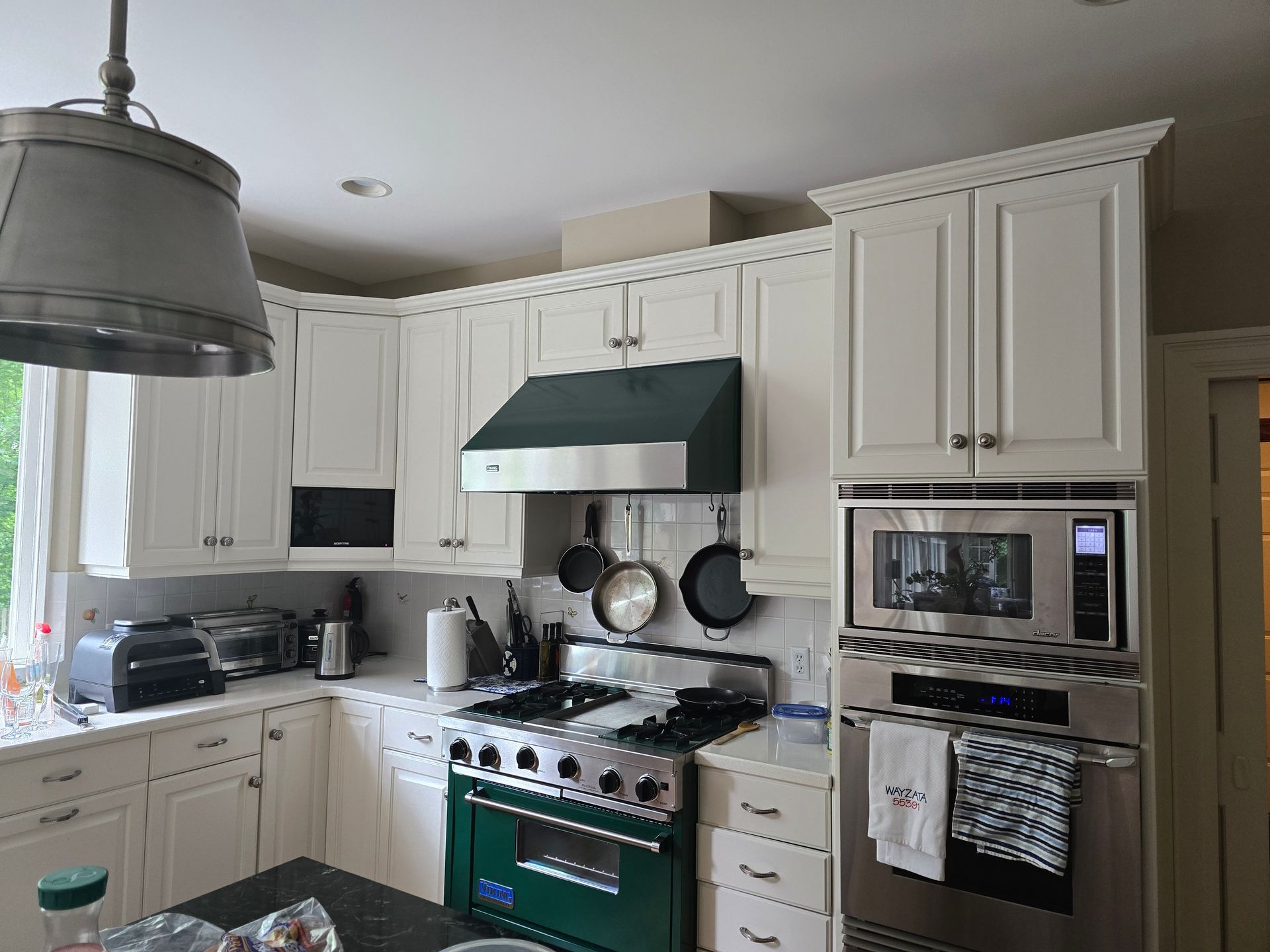 A kitchen with white cabinets and stainless steel appliances
