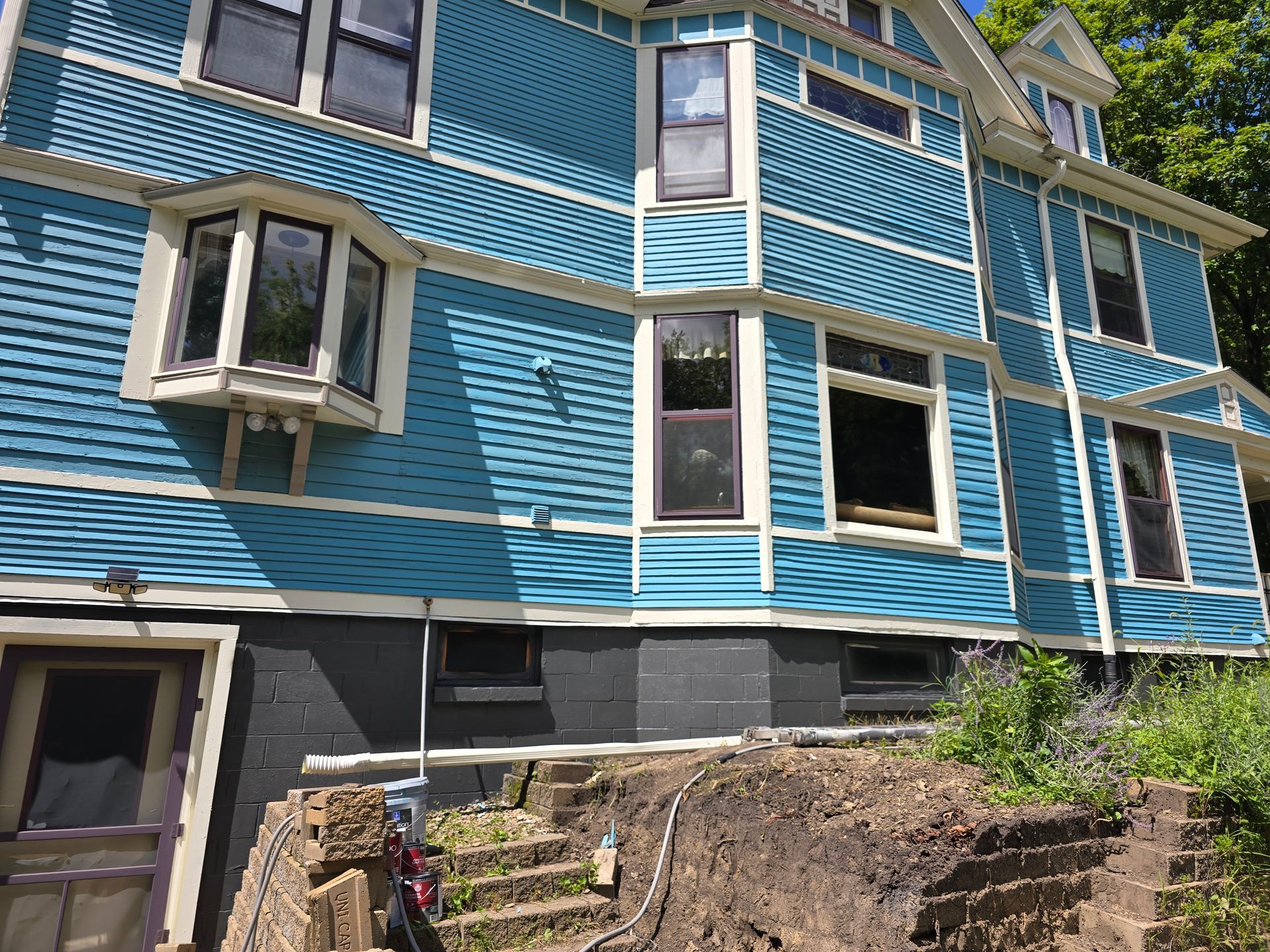 A blue house with a lot of windows and stairs
