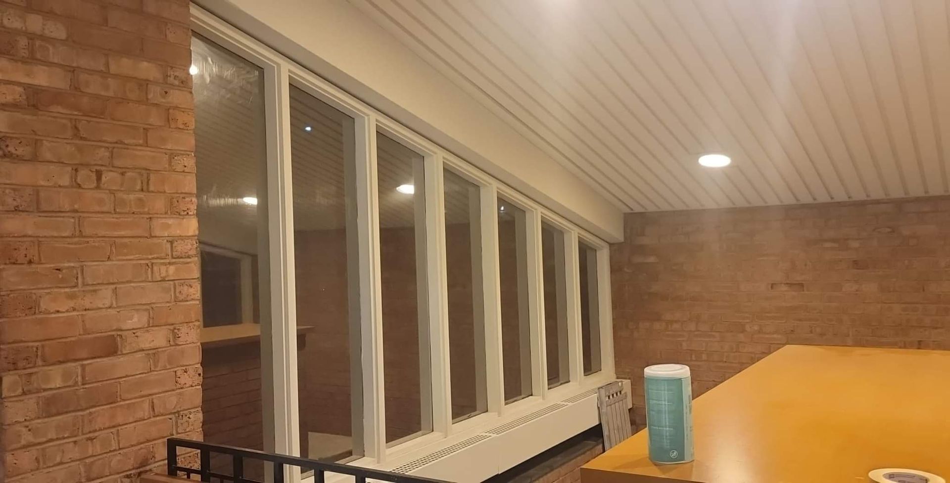A room with a lot of windows and a brick wall.