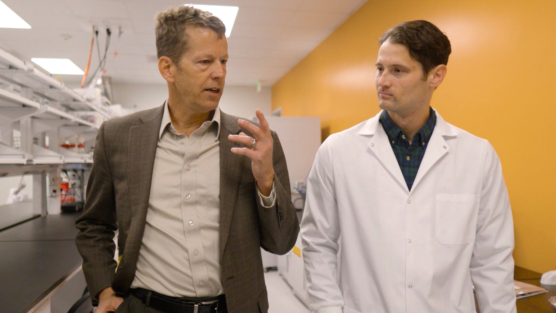 Scientist and patient sharing a hopeful moment inside a biotech lab.