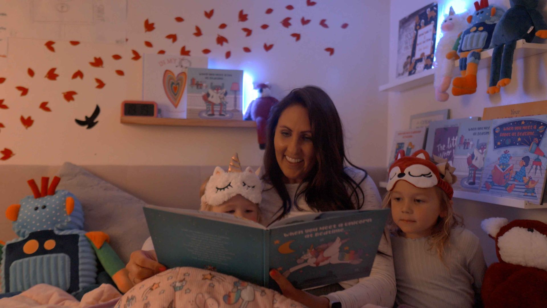 Child hugging a Huggabuddies stuffed animal while reading its matching storybook.