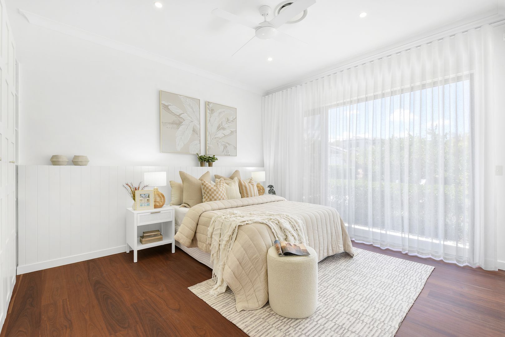A bedroom with a bed , nightstand , rug and ceiling fan.