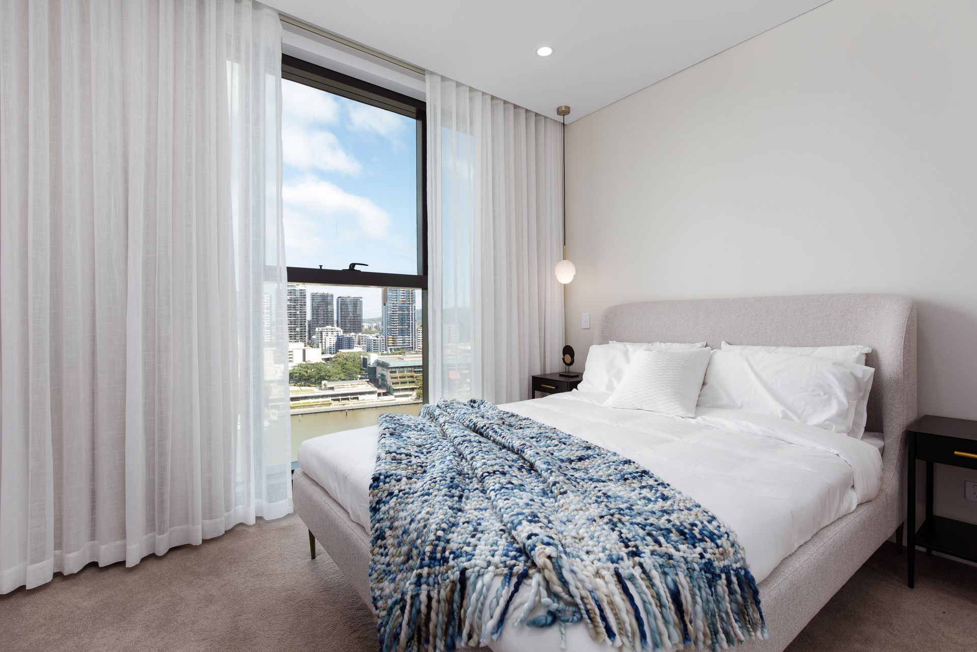 A bedroom with a large bed and a large window.