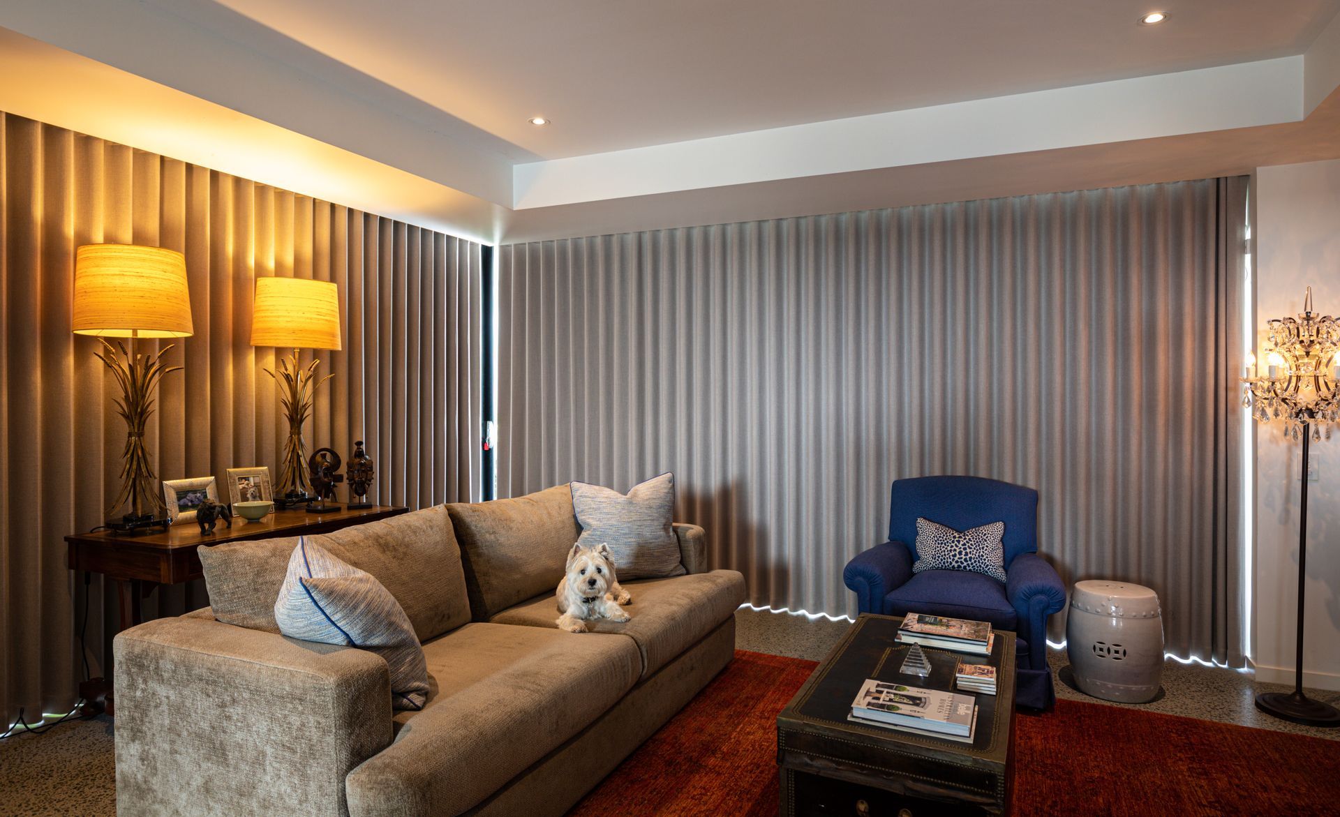 A living room with a couch , chair , coffee table and curtains.
