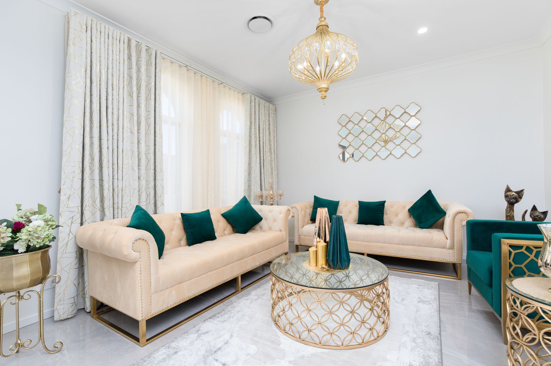 A living room with two couches , a coffee table , and a chandelier.