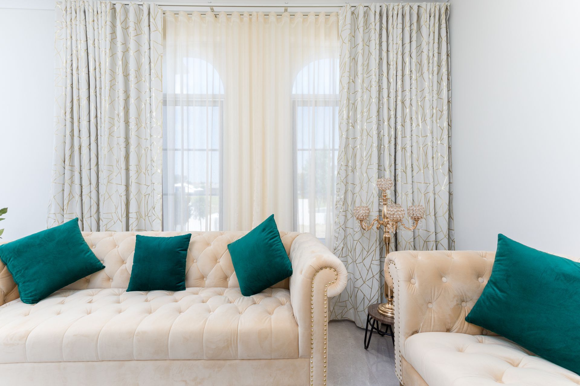 A living room with a white couch and green pillows.
