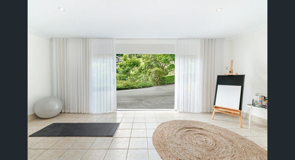 An empty living room with a rug and a large window.