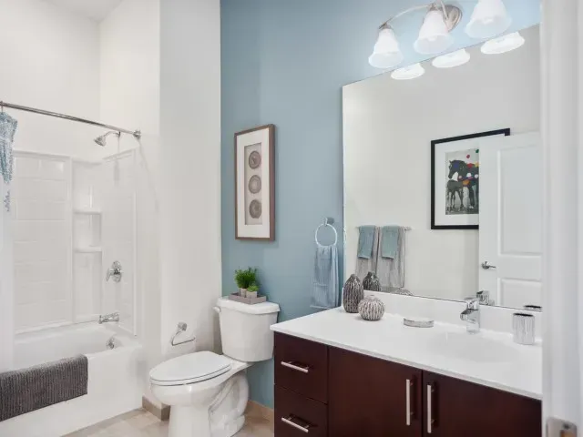 Corsa Tuscan Village modern bathroom with shower/bath, toilet, sink, and mirror. 