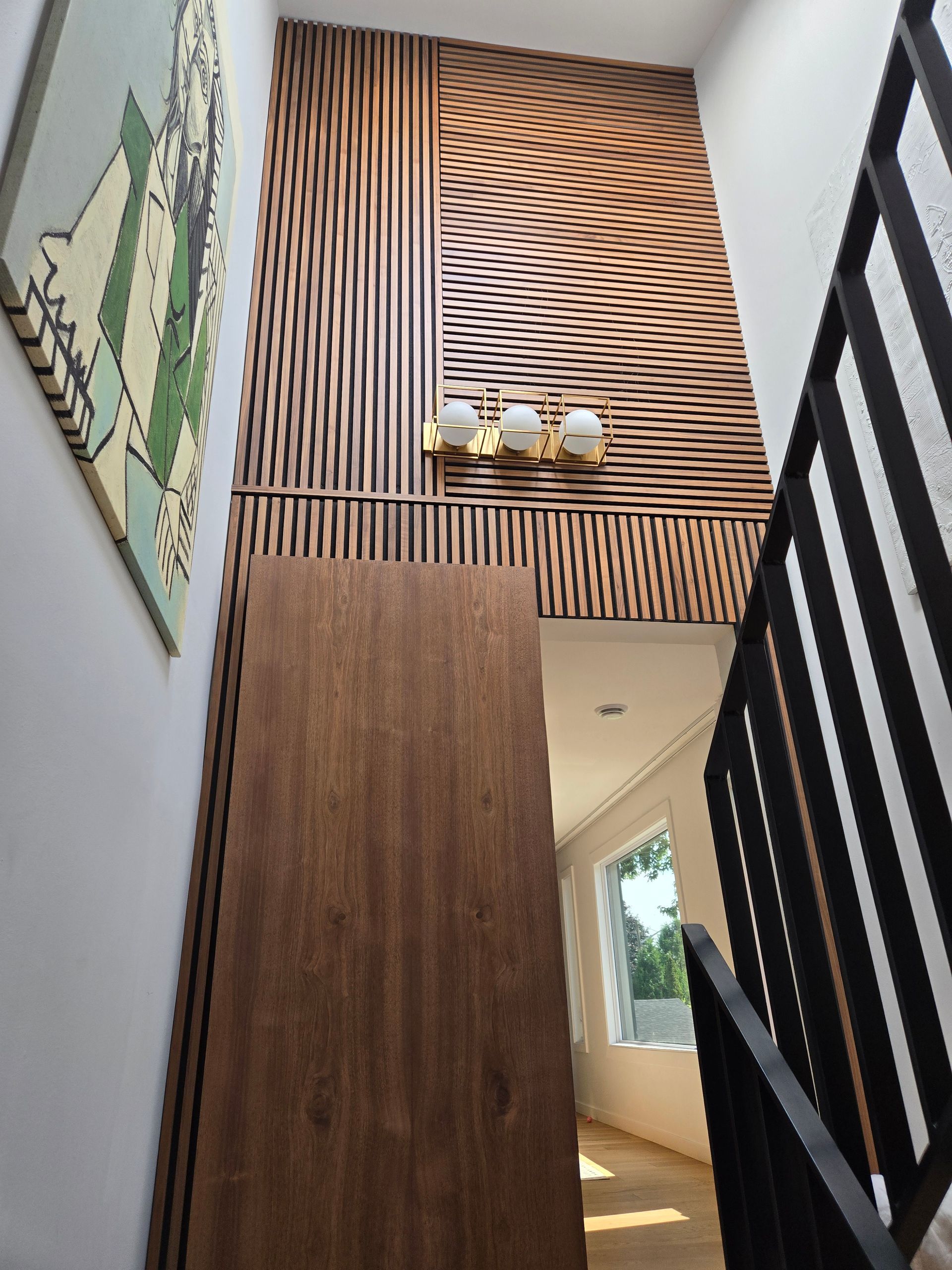 Un escalier avec un mur en bois et un tableau sur le mur.
