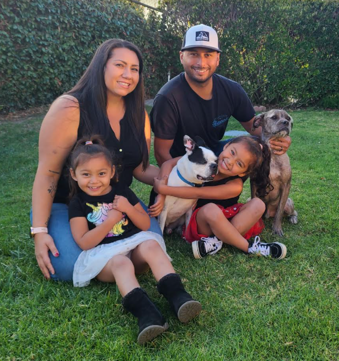A family posing for a picture with their dog