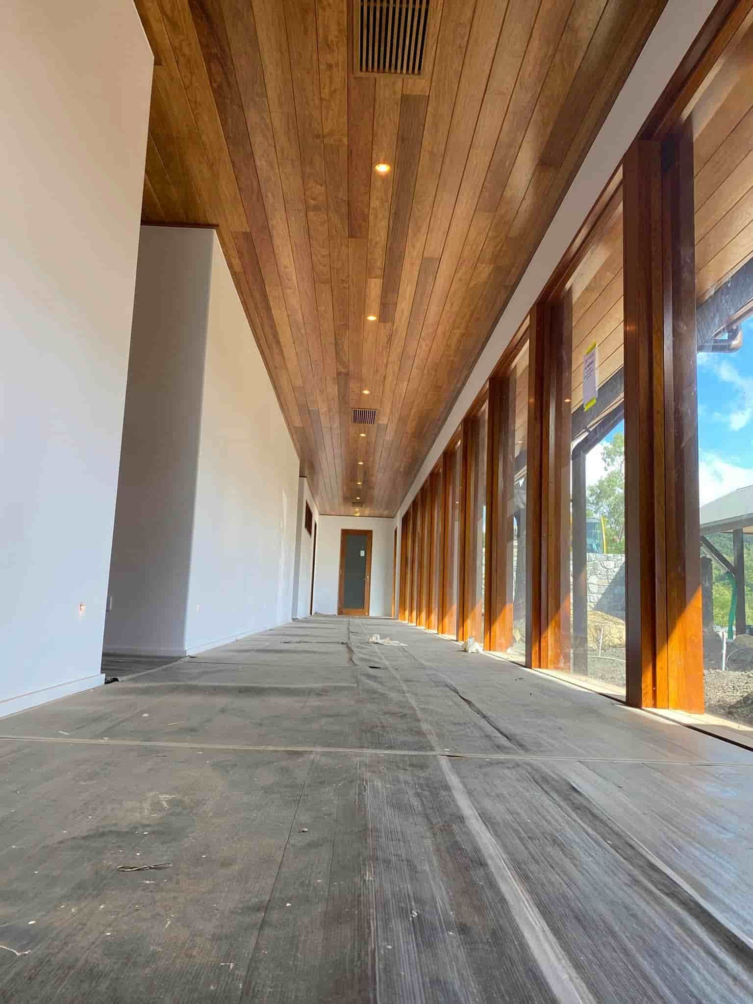 a Long Hallway With a Wooden Ceiling and Lots of Windows — Reef Electrical in Bowen, QLD