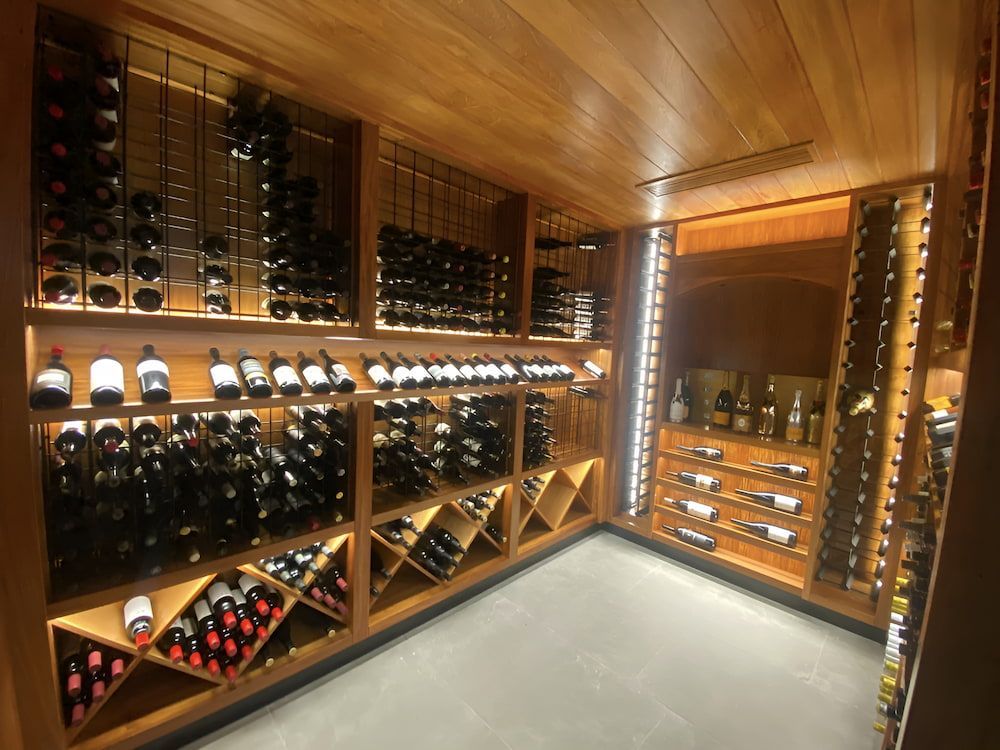 A Wine Cellar Filled With Lots Of Bottles Of Wine — Reef Electrical in Cannonvale, QLD