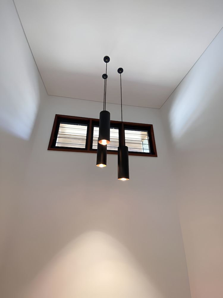 Three Pendant Lights Are Hanging From The Ceiling In A Room — Reef Electrical in Cannonvale, QLD