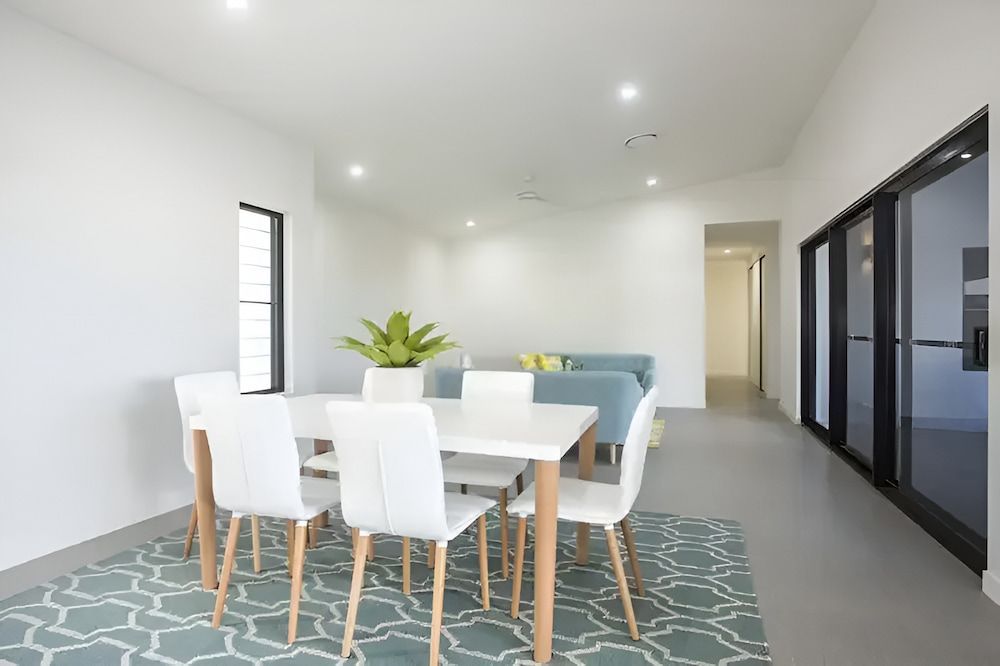 A Dining Room With A Table And Chairs And A Rug — Reef Electrical in Cannonvale, QLD