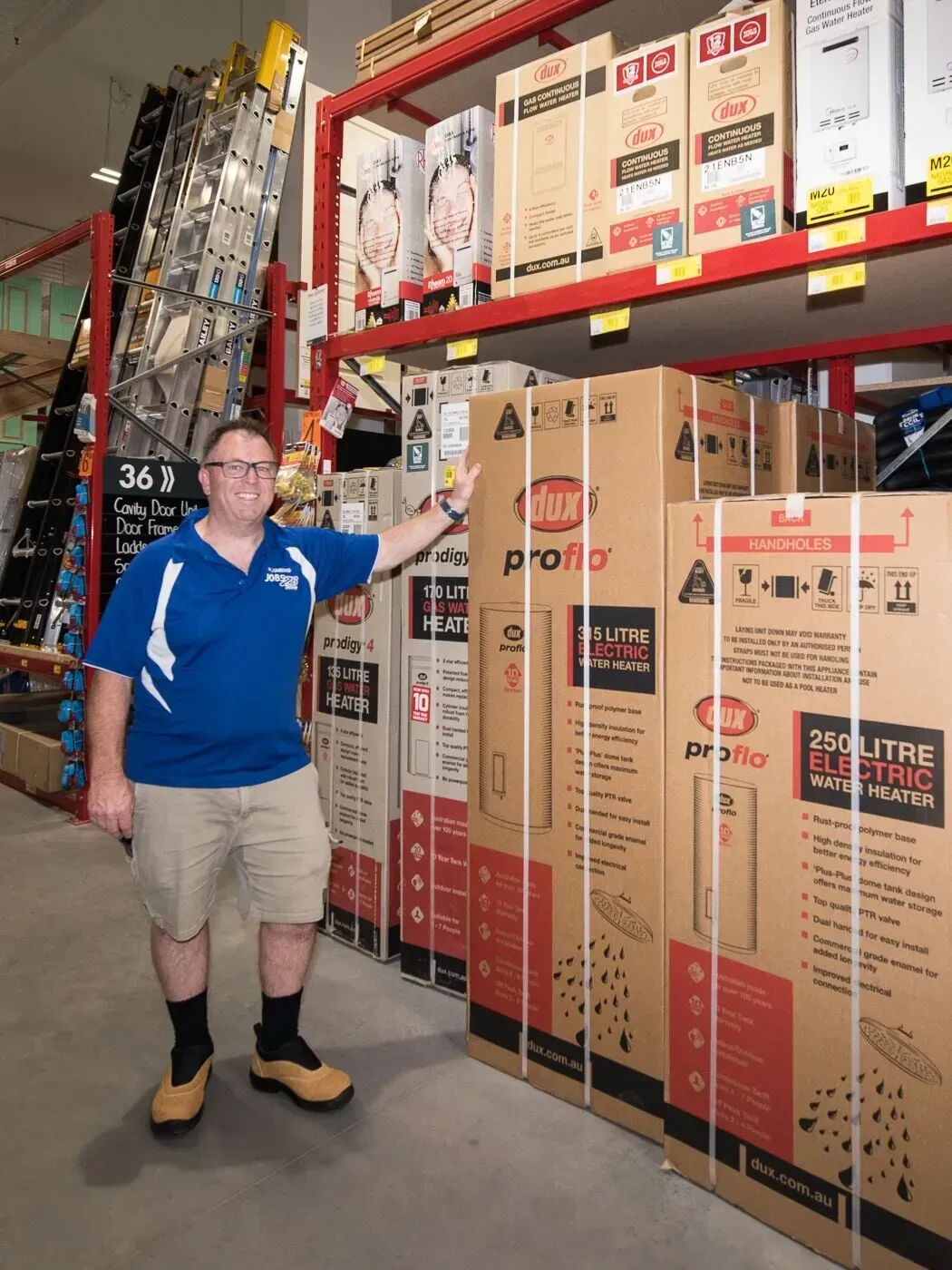 A man in a blue shirt is standing in front of boxes in a store — Jobs2BDone in Avoca Beach, NSW