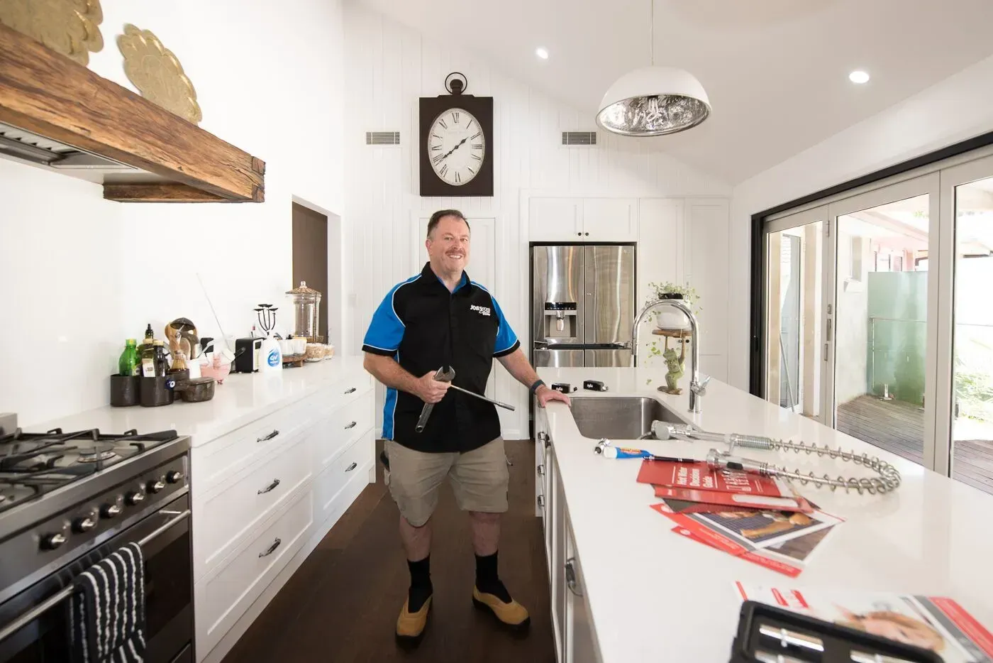 A man is standing in a kitchen with a clock on the wall. — Jobs2BDone in Bensville, NSW