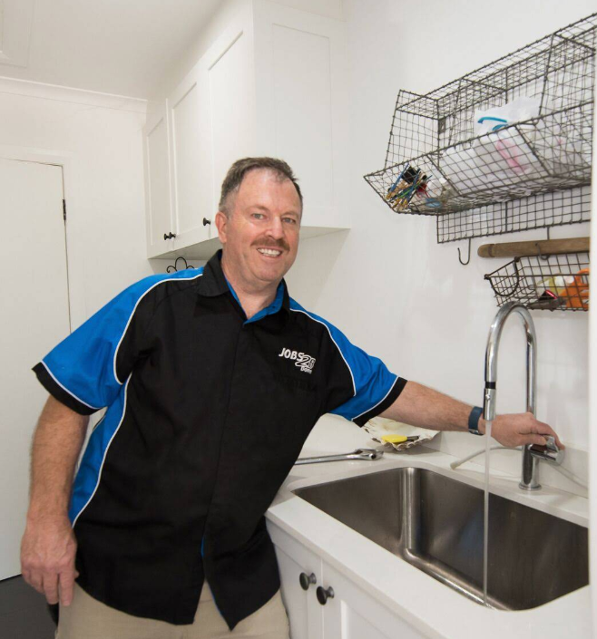 A man in a black and blue shirt is standing next to a sink — Jobs2BDone in Umina, NSW