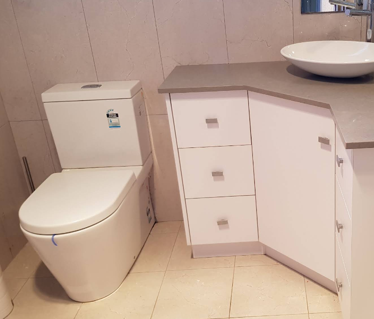 A bathroom with a toilet , sink and cabinets — Jobs2BDone in Bensville, NSW