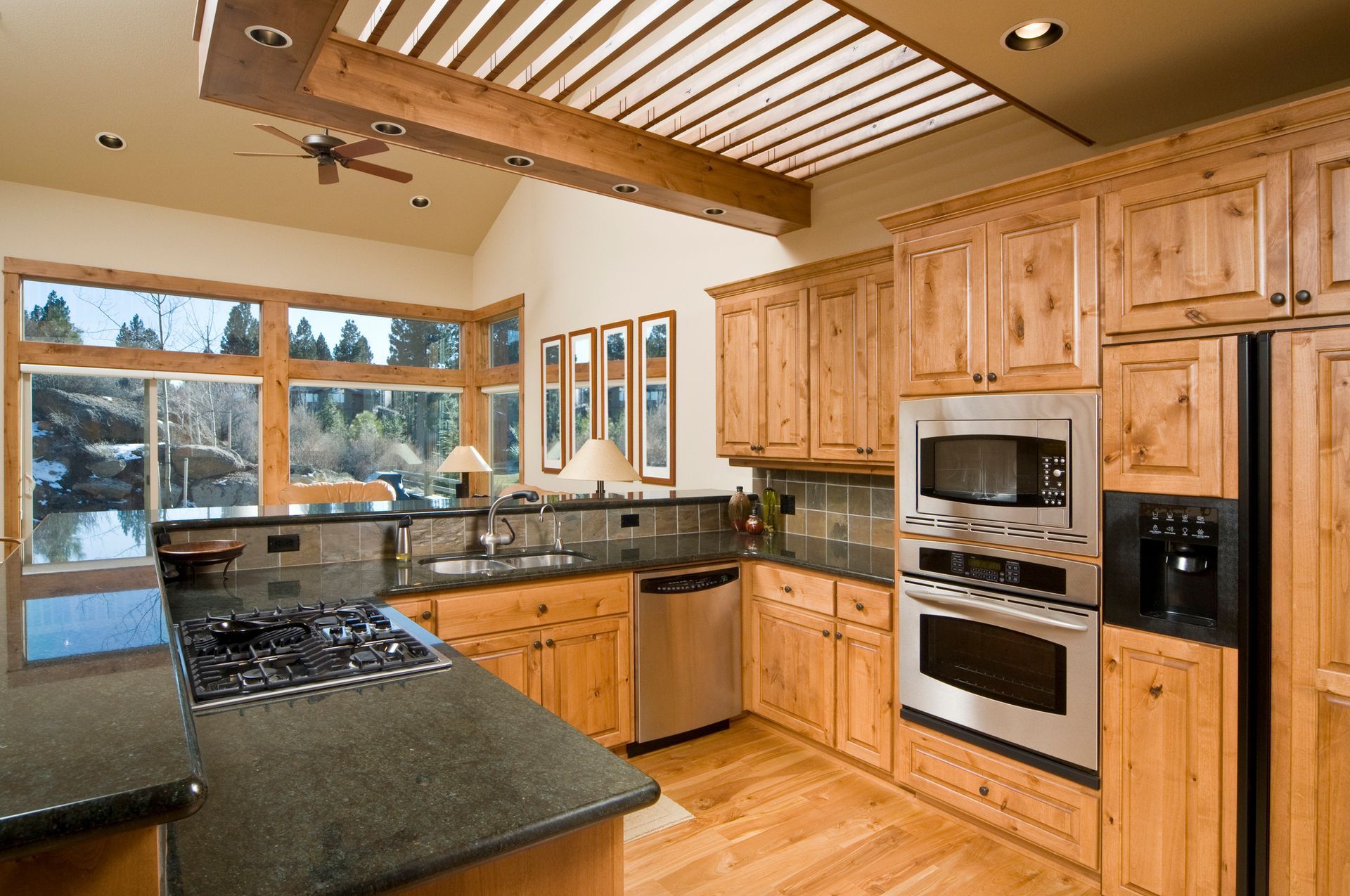 Kitchen with wood cabinets, stainless steel appliances, and dark countertops.