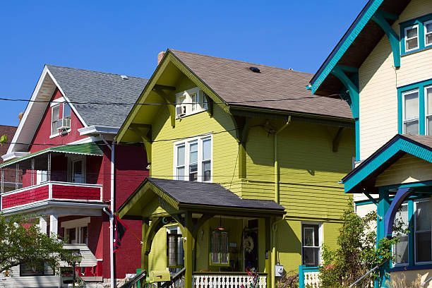 Row of colorful houses with gabled roofs under a clear blue sky.