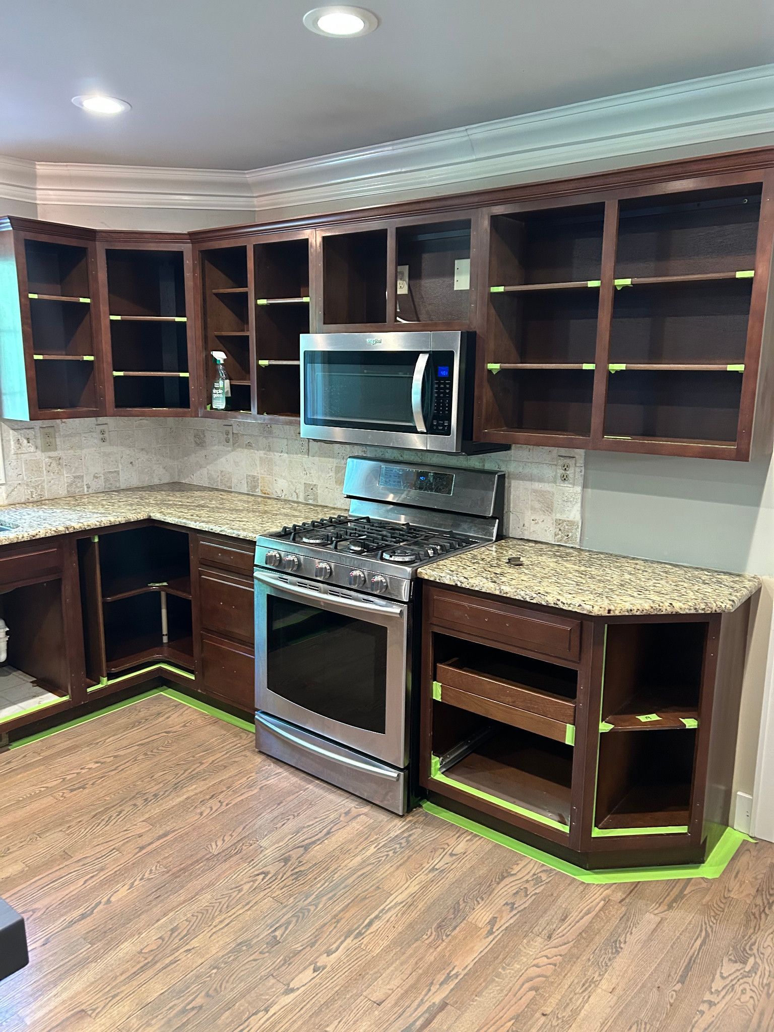 During preparation: cabinet doors removed and surfaces masked before painting.
