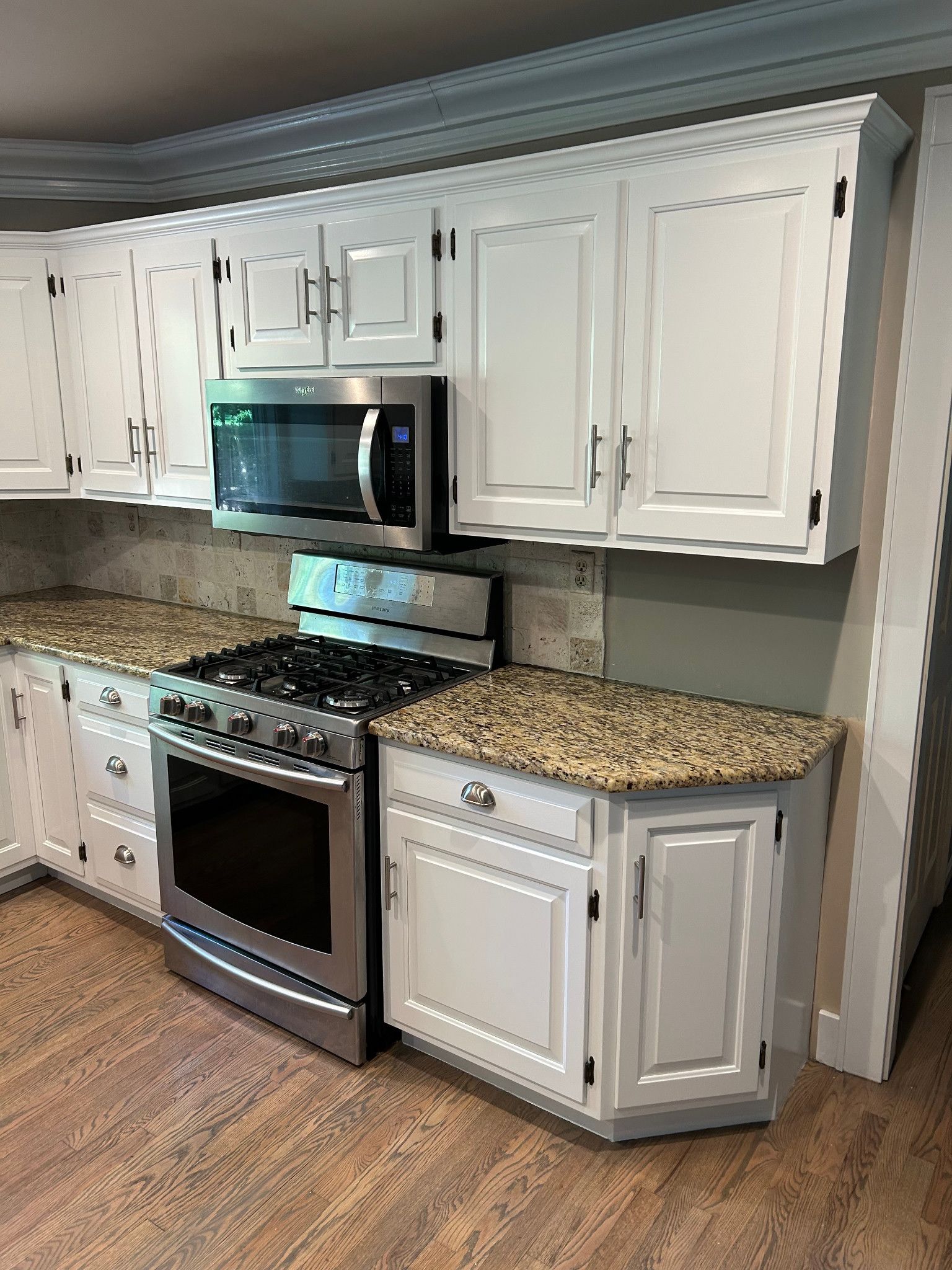 White painted kitchen cabinets with metal hardware after cabinet painting.