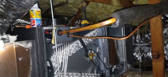 Flooded basement with standing water, exposed pipes, and a tool on a wet wooden beam.