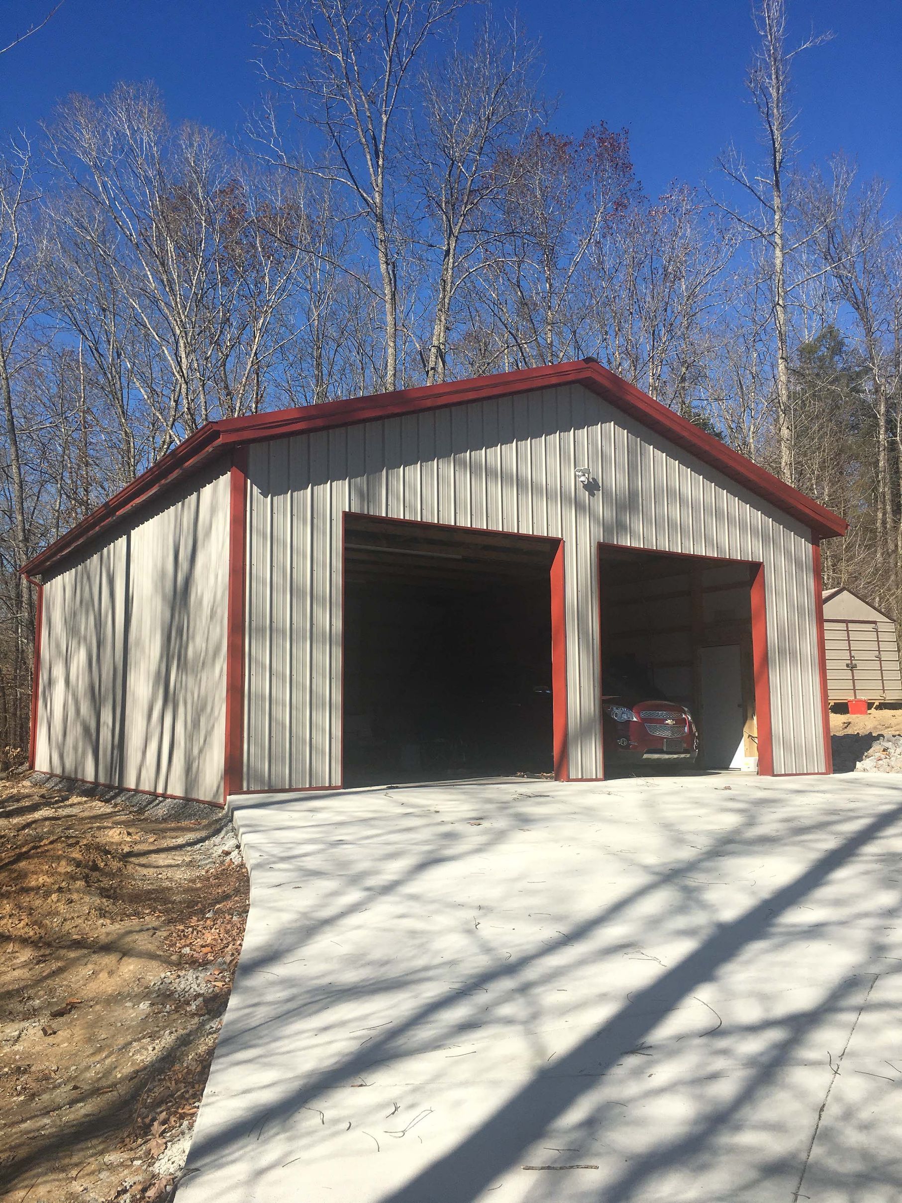 A car is parked in a garage with a red roof.