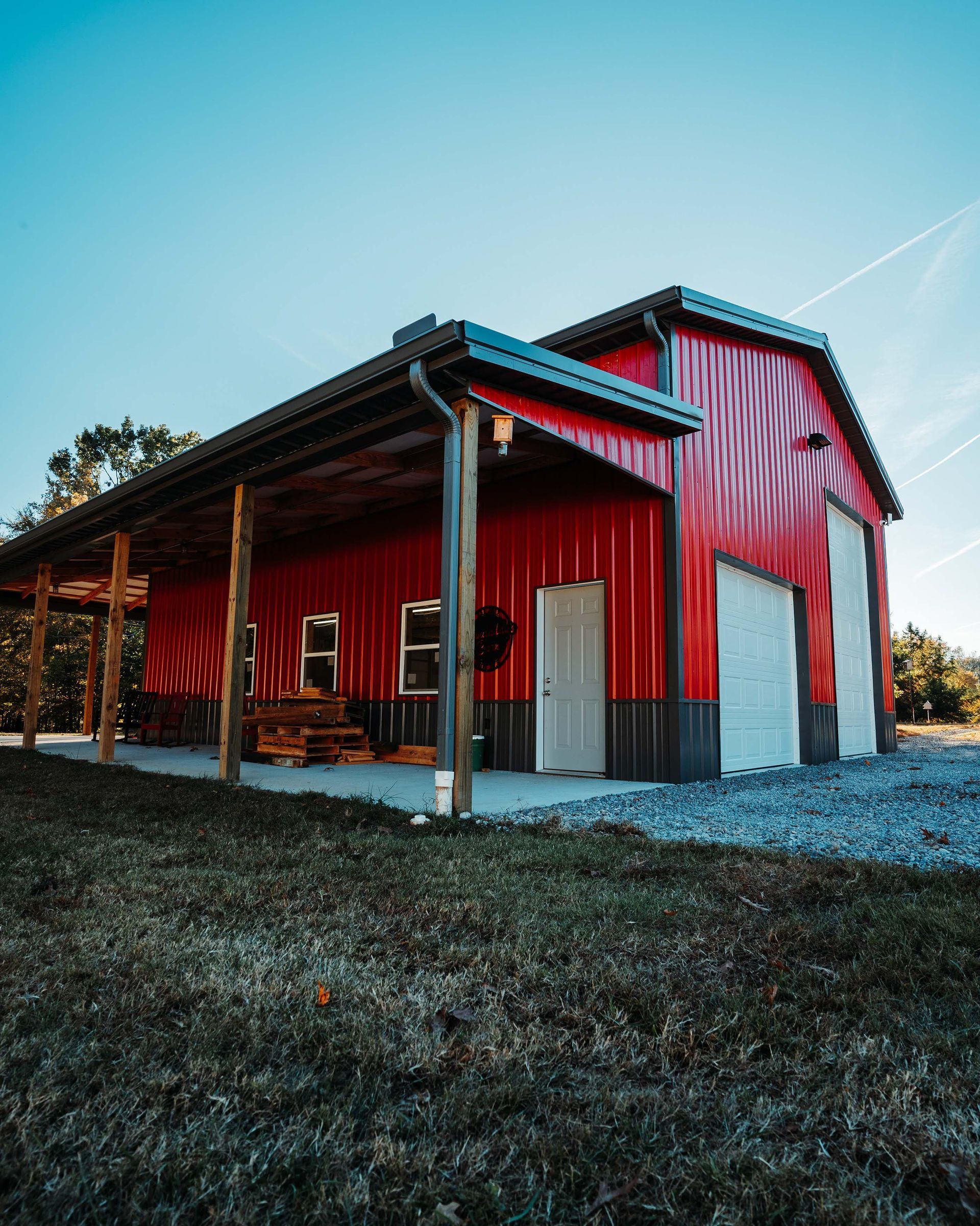 A red barn with a porch and a blue sky in the background.