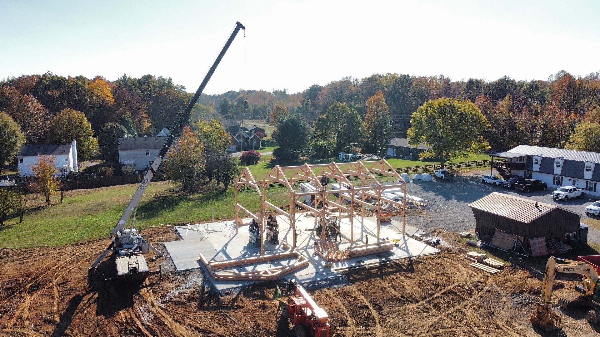 An aerial view of a construction site with a crane in the foreground.