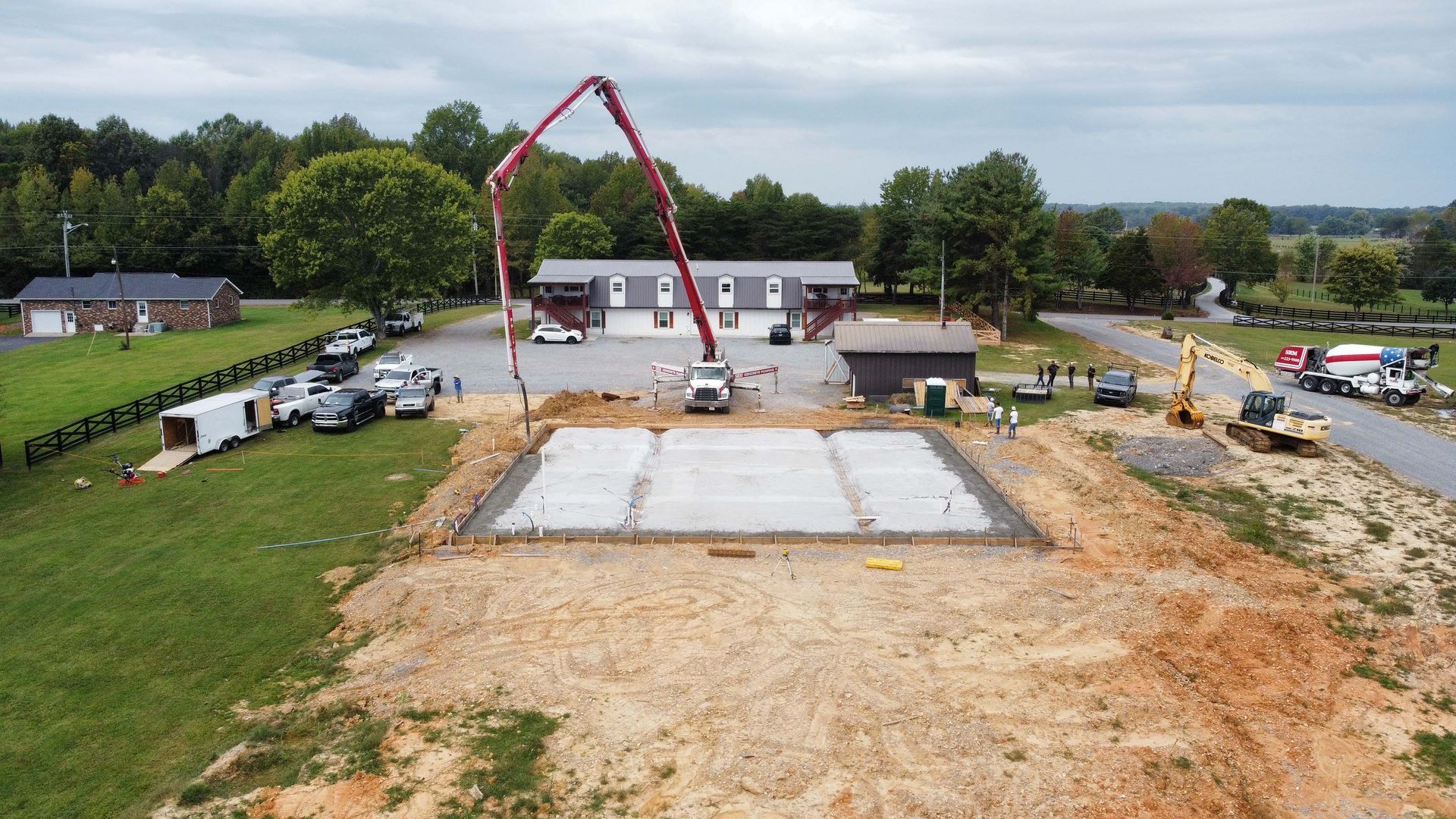 An aerial view of a construction site with a building in the background.