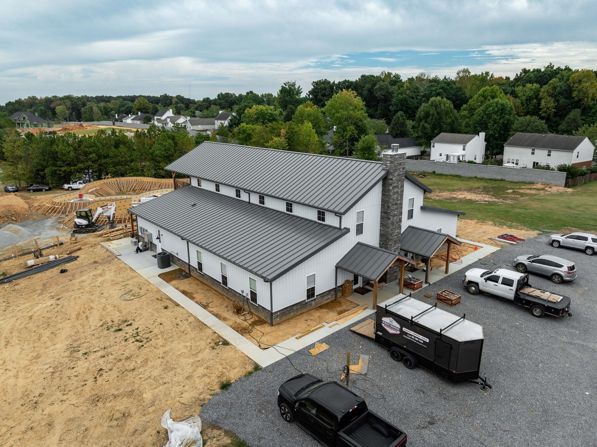 An aerial view of a building under construction with trucks parked in front of it.