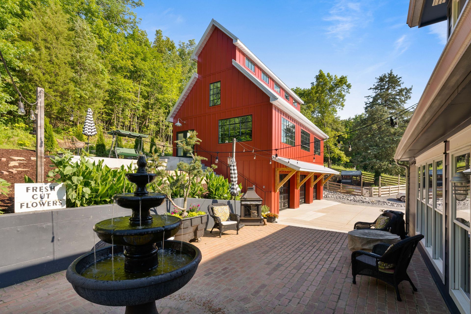 A red barn with a fountain in front of it