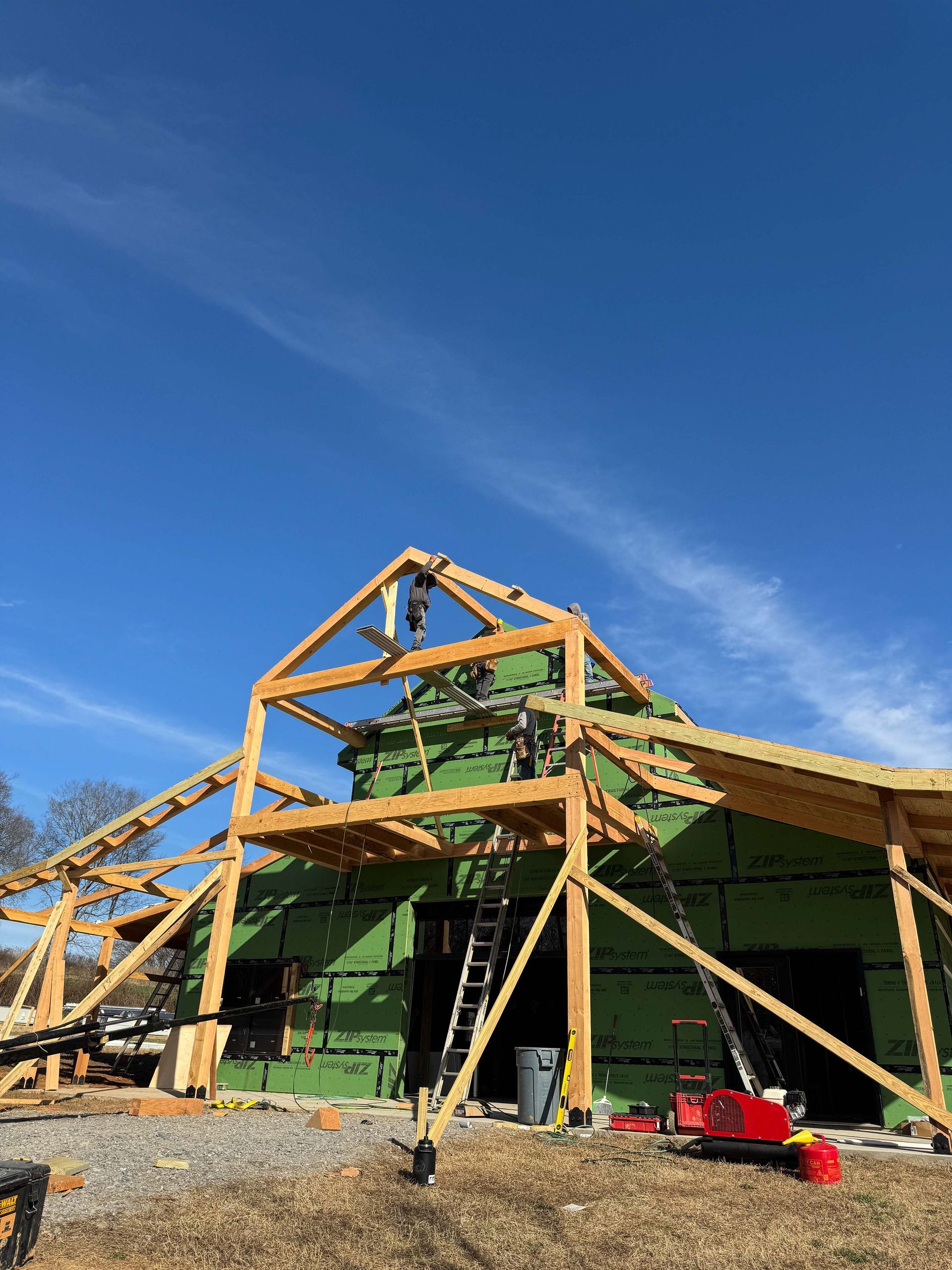 A large wooden structure is being built in a field.
