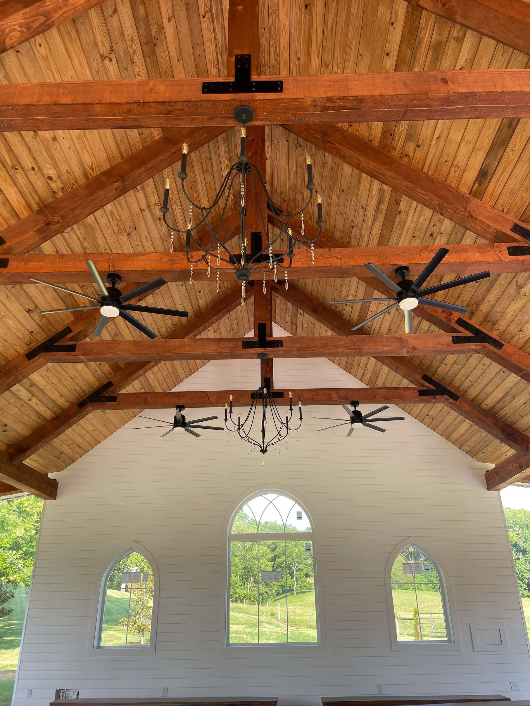 A church with a wooden ceiling and a chandelier hanging from it.