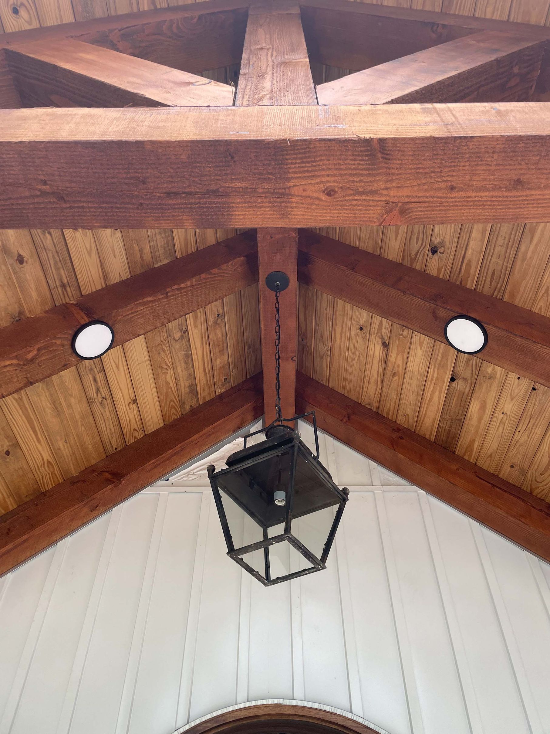 A wooden ceiling with a lantern hanging from it.