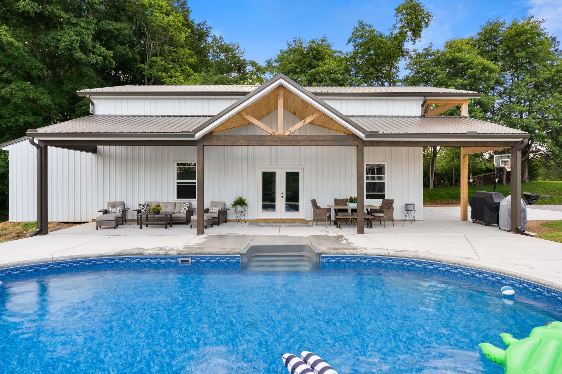 A large white house with a swimming pool in front of it.