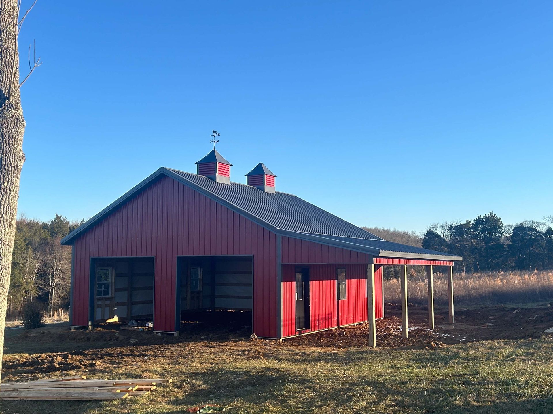 A red barn is sitting in the middle of a field.